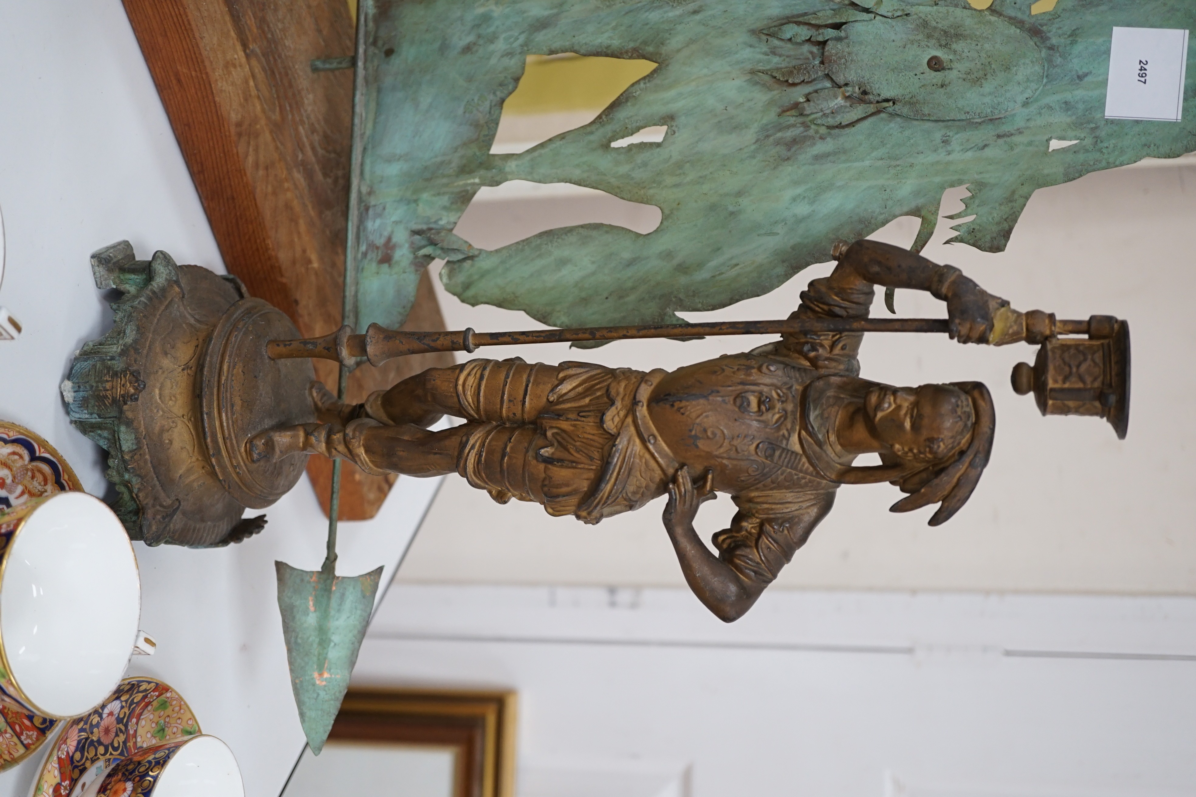 A spelter figural candlestick, a weather vane, a bronze wheel-barrel and a spade, Weather vane 51 cms high not including base
